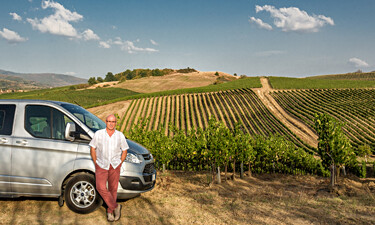 Tuscany tour guide Sergio with his van in a Chianti vineyard